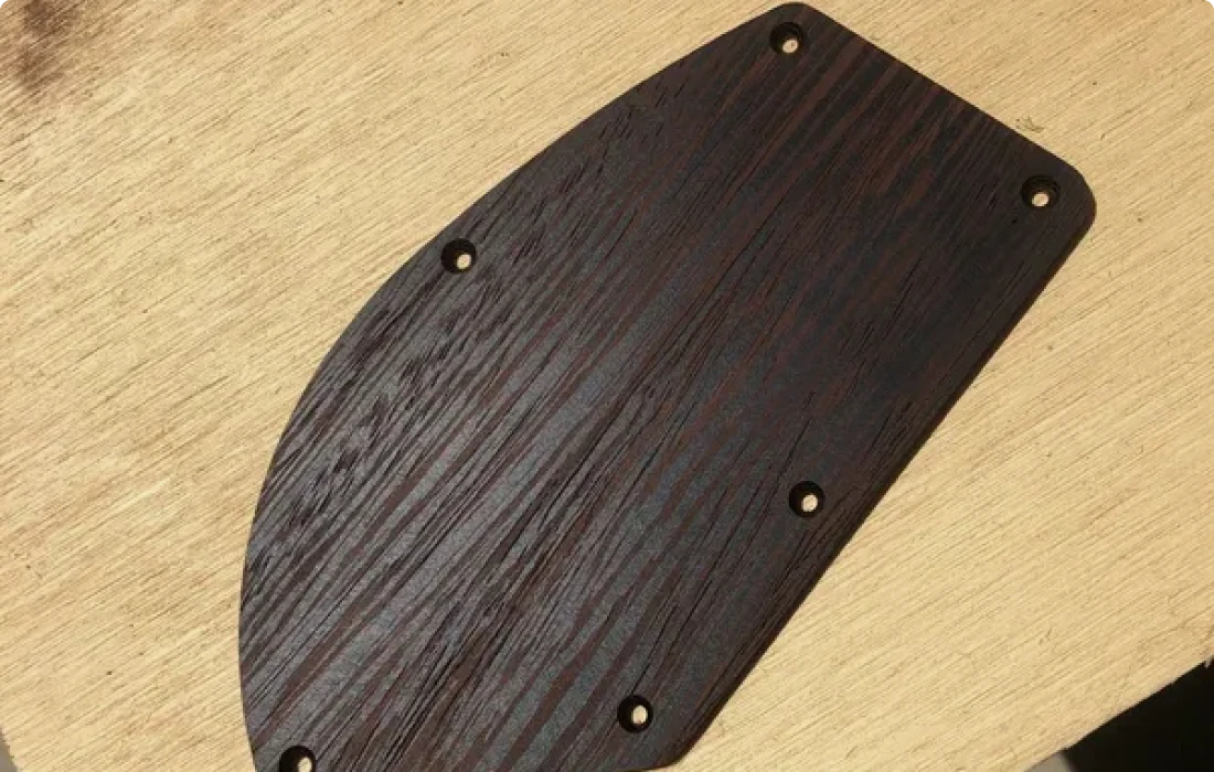 Dark wood panel with drilled holes
